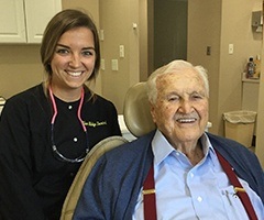 Team member and smile senior man in dental exam chair