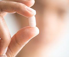 Hand holding a white sedative tablet