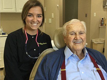 Team member and smiling senior dental patient