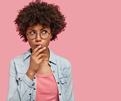 Pondering woman with questions for her Charlottesville cosmetic dentist