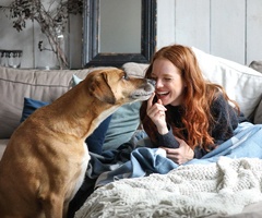 person smiling and petting a dog