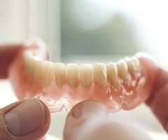 person holding dentures