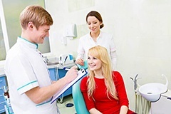 Woman in dental chair smiling at dentist