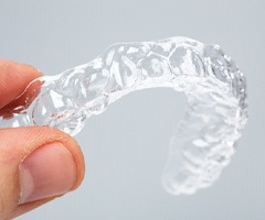 A person holding a clear aligner.