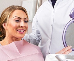 Woman looking at healthy smile in mirror