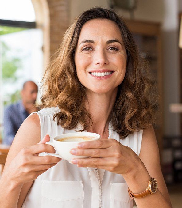Smiling woman holding cup of coffee
