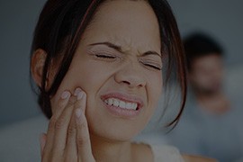 Woman holding jaw in pain