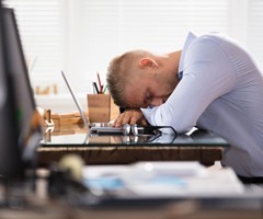 A man sleeping at his desk.