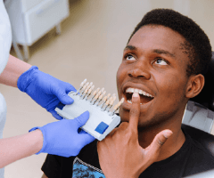 Man’s smile compared with tooth color chart