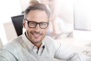 Confident businessman with glasses smiling